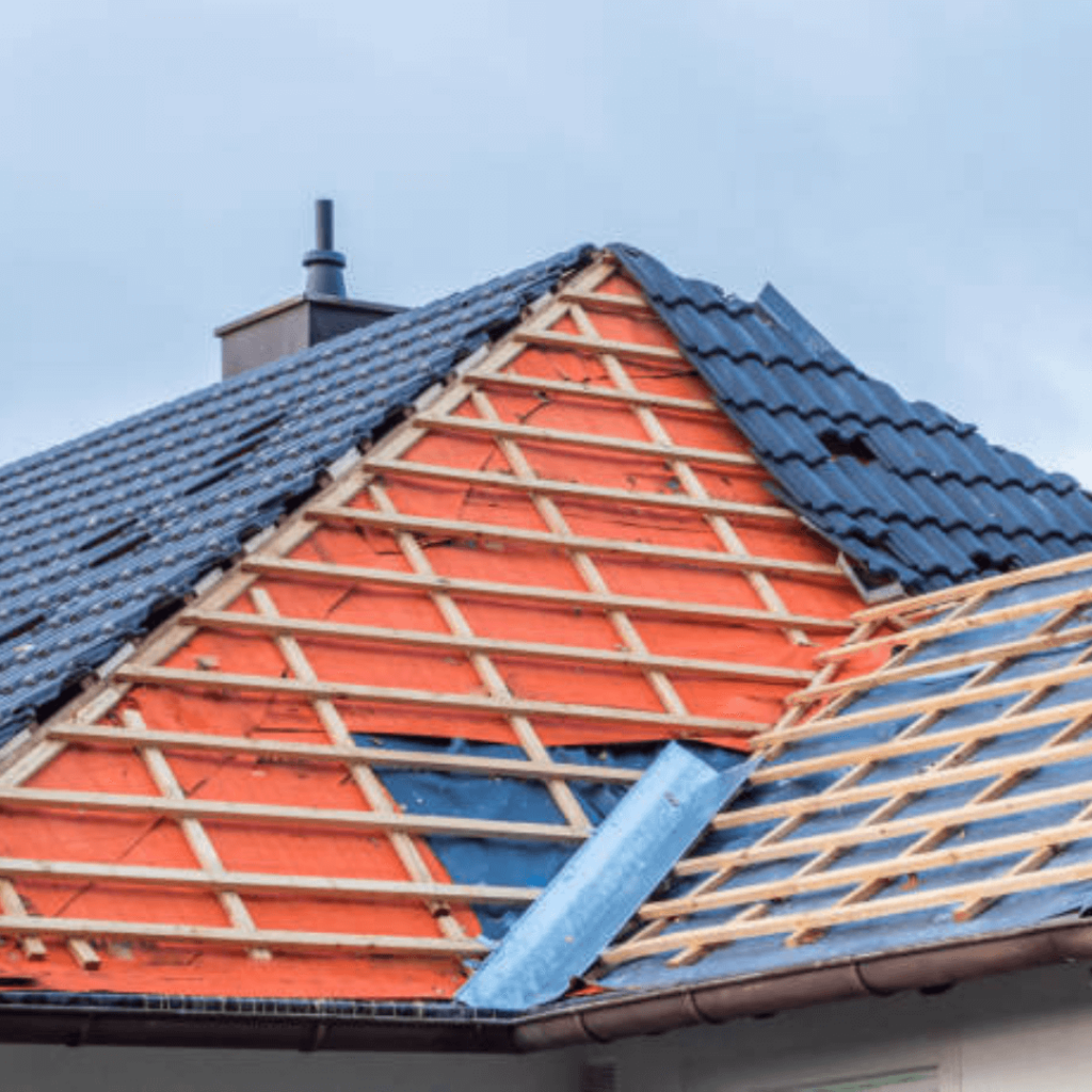 Teilweise saniertes Dach eines Wohnhauses mit neuer Holzunterkonstruktion und schwarzer Dacheindeckung. Dachsanierung in Vorbereitung für eine moderne Bedachung