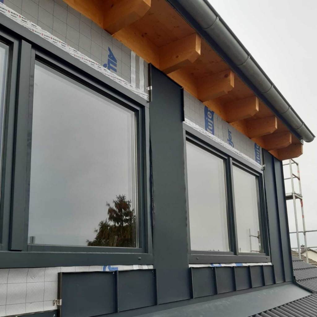 Dachgaube mit anthrazitfarbener Metallverkleidung und großen Fenstern auf einem modernen Steildach. Hochwertige Dachgauben-Verkleidung für optimalen Witterungsschutz und modernem Design.
