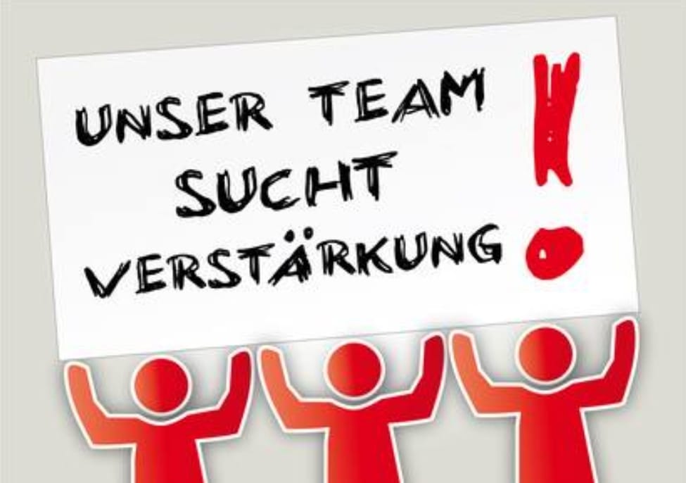Grafik mit drei stilisierten roten Figuren, die ein Schild hochhalten. Auf dem Schild steht in handschriftlicher Schrift: 'Unser Team sucht Verstärkung!' mit einem großen roten Ausrufezeichen.